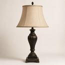 Decorative table lamp with a beige shade on a plain background
